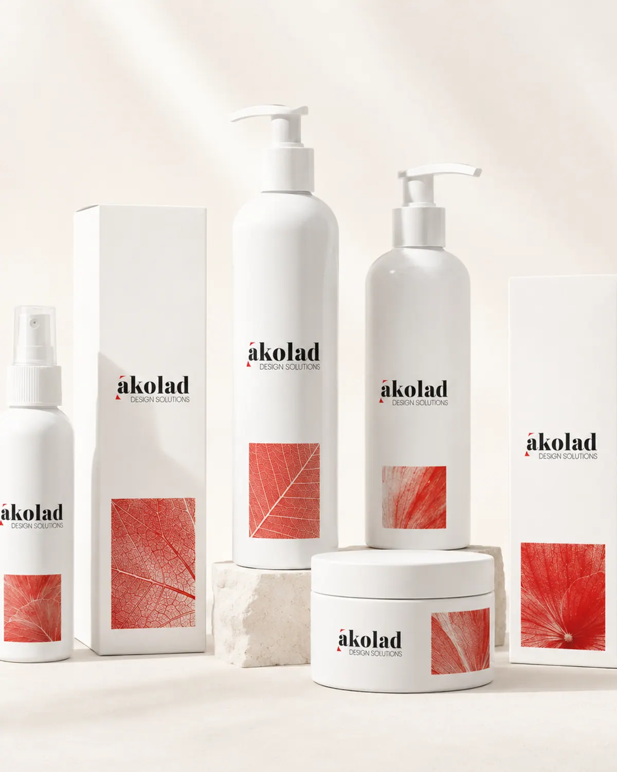A range of white cosmetic bottles, jars and cartons with red botanical imagery, arranged on stone plinths.